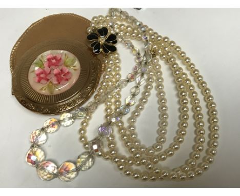 A pearl necklace and bracelet, together with a glass bead necklace and compact with flower design inset