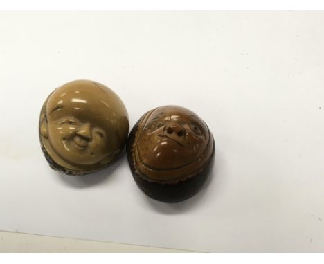 Two Japanese Beatle nut Netsuke In the form of faces signed .