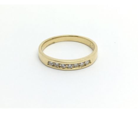 An unmarked possible 18carat gold ring set with a row of seven brilliant cut diamonds. ring size N-O