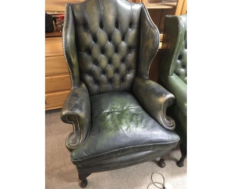 A Green leather wing arm chair with a button back and drop in seat of mid 18th century style.