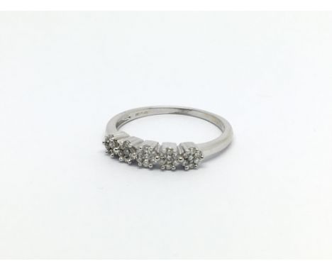 An 18carat white gold ring set with a row of five round clusters of diamonds ring size M-N