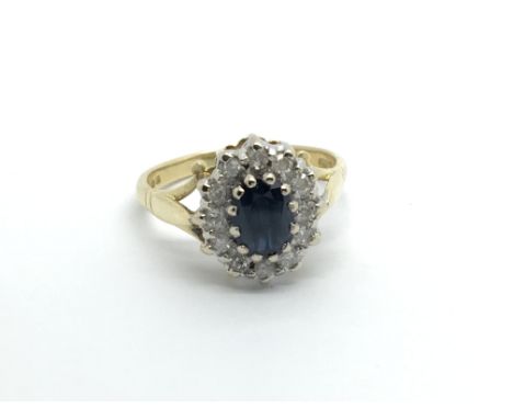 An 18carat gold ring set with a blue sapphire flanked by an oval of diamonds ring size P-Q