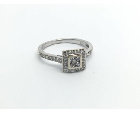 An 18carat white gold ring set with a square pattern of diamonds with diamonds set in the shank ring size K-L