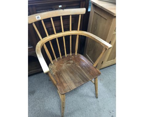 A Ercol style stick back open arm chair the solid seat on turned legs United by stretchers.