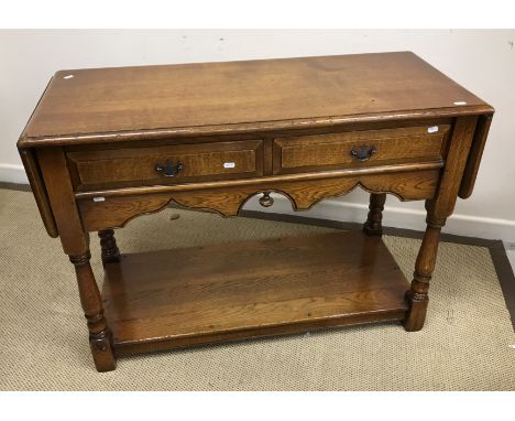A modern oak two drawer side table in the 18th Century manner, the two drop leaves raised on turned supports to block feet, u