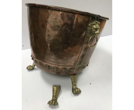 A Victorian copper copper of typical form now with lion mask ring handles and brass paw feet as a log bin 48 cm diameter x 44