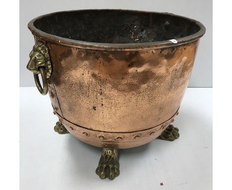 A Victorian copper copper of typical form now with lion mask ring handles and brass paw feet as a log bin 45 cm diameter x 36