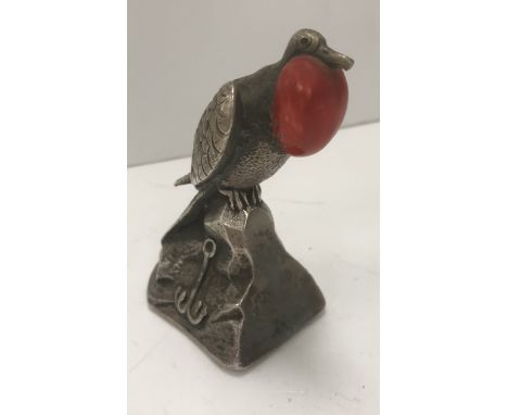 An early 20th Century white metal and enamel decorated frigate bird with throat expanded sat on a rocky outcrop, decorated wi