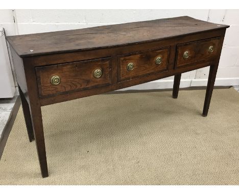 An early 19th Century North Country elm and cross banded dresser, the single piece top over three drawers with brass ring han