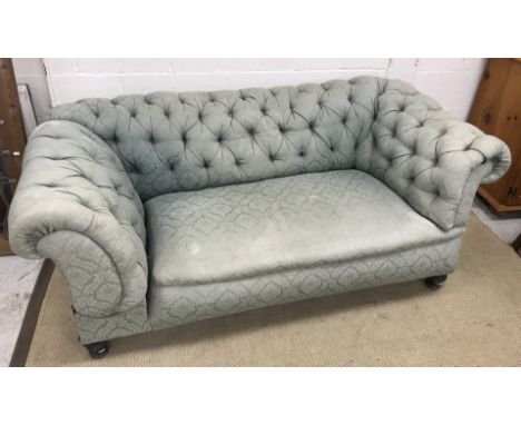 A late Victorian buttoned upholstered Chesterfield scroll arm drop end sofa, on turned and ringed front legs, 184 cm wide x 9