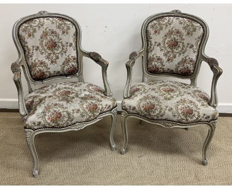 A pair of circa 1900 painted framed elbow chairs in the Louis XV taste, with floral tapestry style upholstery on cabriole fro