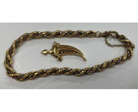 An 18 carat gold bi-colour rope-twist bracelet, 19 cm long and an 18 carat gold curved dagger pendant, overall weight 15.3 g