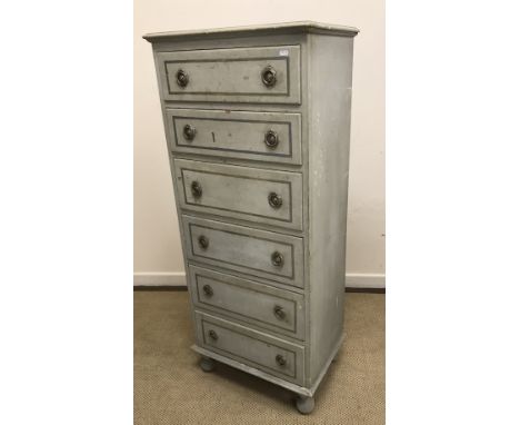 A painted pine slim chest of six drawers with ring handles on turned feet, 60 cm wide x 40 cm deep x 142 cm high, together wi