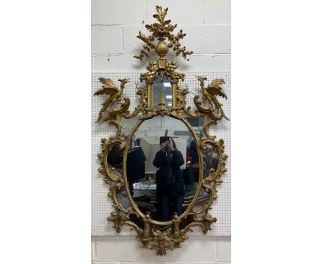 An 18th Century carved giltwood and gesso framed wall mirror in the Chinese Chippendale taste, the oval plate within a multip