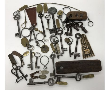 A collection of 24 various keys, mostly with brass and other tags, including “Guard House”, “Wharf Gates & Pump/22”, “Stores”