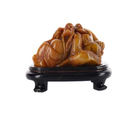 20TH CENTURY CHINESE SHAO SHAN STONE SEAL, modelled as a reclining figure and attendant, 11cm long, on a wood stand