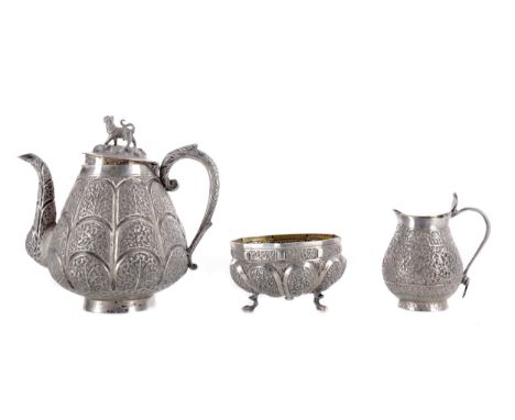 INDIAN WHITE METAL THREE PIECE TEA SERVICE, comprising tea pot, sugar and cream, embossed overall with foliate designs, the t