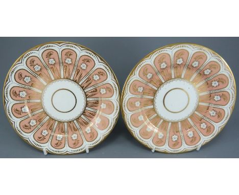 A pair of early nineteenth century porcelain tea plates, possibly Chamberlains, c. 1820.  Each piece is gilded with flowers o