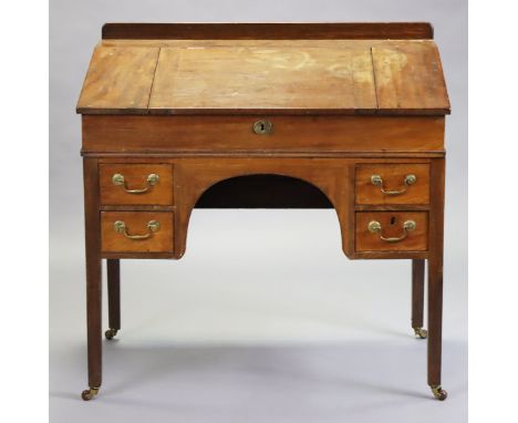 A Victorian mahogany clerks’ desk with a fitted interior enclosed by a sloping hinged lid, fitted four short drawers with bra