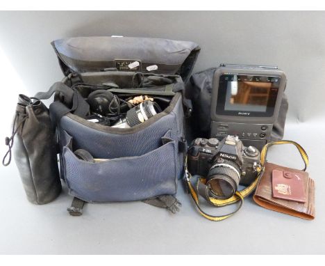 A Nikon F-300 SLR camera with Nikkor 28mm 1:2.8, 55mm 1:2.8 macro and 135mm 1:2.8 lenses and further accessories