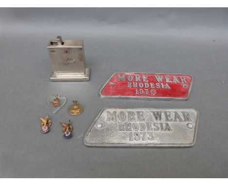 Two cast "More Wear" Rhodesia 1976 and 1973 engine plates, a pop-up German cigarette lighter, lucite sweetheart military RAF 