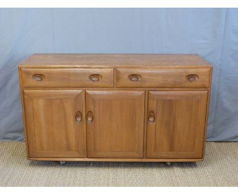 A retro Ercol light elm sideboard with an arrangement of two drawers over three doors (H81 x W106 x D45cm)