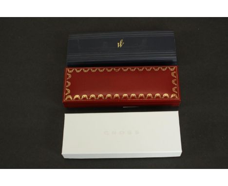 Three pens in boxes, including a cased Cartier "must de Cartier" steel-coloured lacquered metal and gold plated ballpoint pen