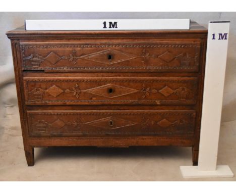 A 19th century French provincial oak commode chest, the plank top over three long drawers, each ornately carved with three lo