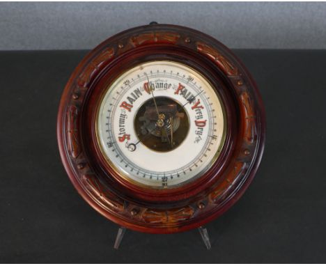 An early 20th century carved mahogany framed barometer with white enamel dial. Diam.29cm 