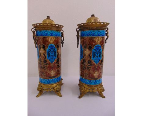 A pair of French enamelled cylindrical lamp bases with gilt metal mounts on four lion mask scroll supports, marks to the base