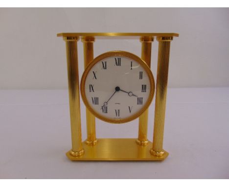 A gilt metal architectural form mantle clock, white enamel dial with Roman numerals