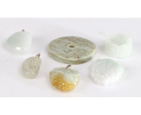 Jade carvings, to include two fruiting vine pendants, ring, circular disc, two carved pendants (6)