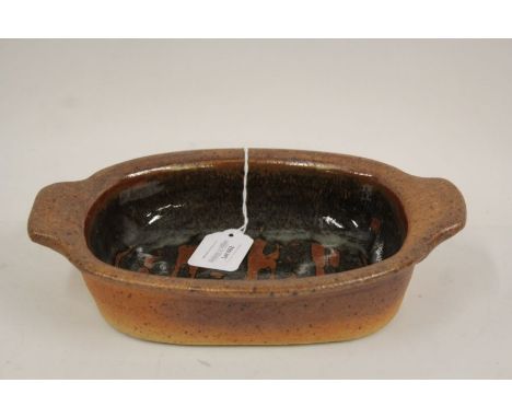 John Leach for Muchelney Pottery, a twin handled dish,, the central field with wax resist decoration25cm wide, 18cm deep, 5.5