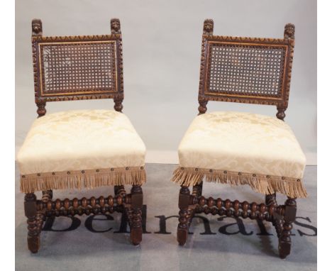 A set of six Charles II style carved oak dining chairs, with cane back panels, upholstered stuff-over-seats, on bobbin turned