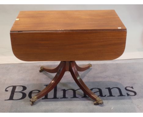 A Regency mahogany ebony banded supper table, with hinged drop leaves, end drawer, on a ring and baluster turned pillar and q