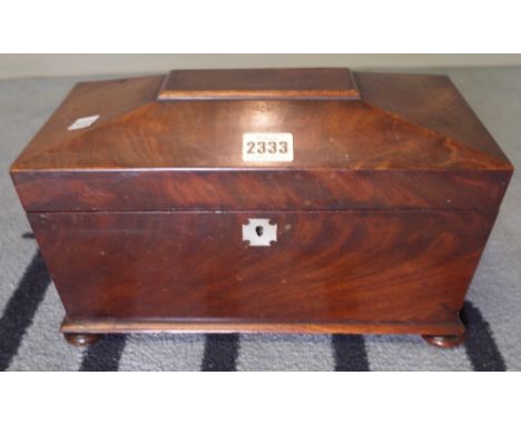 A Regency mahogany tea caddy of sarcophagus form on bun feet, 31cm wide x 19cm high.