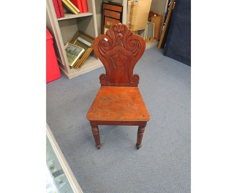 A Victorian mahogany hall chair having a scroll shaped back on bobbin turned and tapered legs