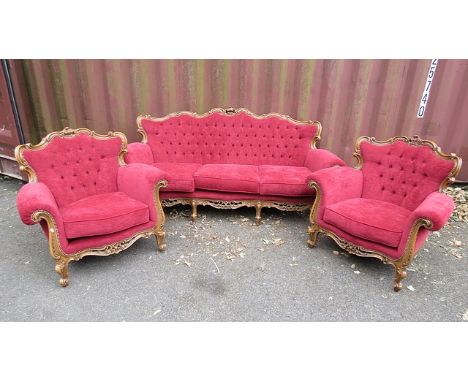 A late 20th century French style sofa and two matching armchairs having a carved walnut frame