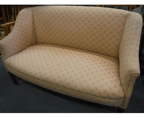 A two-seater Edwardian salon sofa in a light pink upholstery on mahogany tapering legs