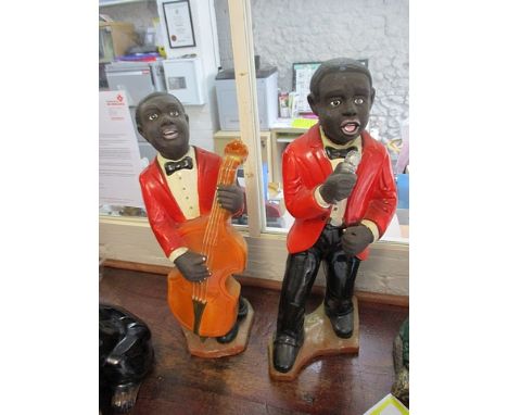 A pair of ceramic gentlemen, one singing, the other playing the bass