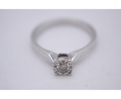 A 9 carat white gold illusion set diamond solitaire ring. Set with a round brilliant cut diamond with an approximate diamond 