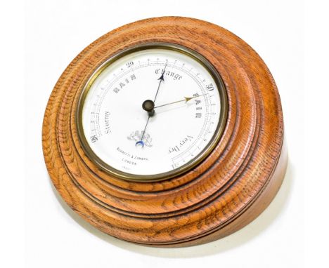 NEGRETTI &amp; ZAMBRA; a brass cased aneroid barometer, the circular dial no.14,291, diameter 12cm, fitted in later oak stand