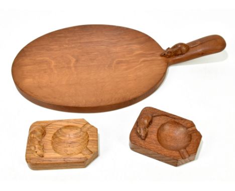 WORKSHOP OF ROBERT 'MOUSEMAN' THOMPSON; an adzed oak cheeseboard of oval form, length 38cm, with two ashtrays, length 10cm (3