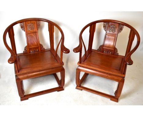 A pair of modern Chinese redwood hoop back armchairs with carved scroll detail, planked seat and shaped low stretchers.