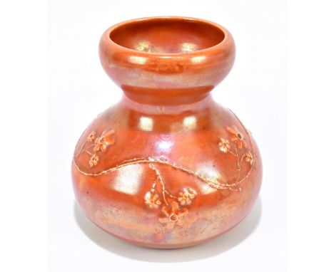 RUSKIN; a bulbous vase with flared neck relief decorated with floral detail on an orange lustre ground, impressed marks and d