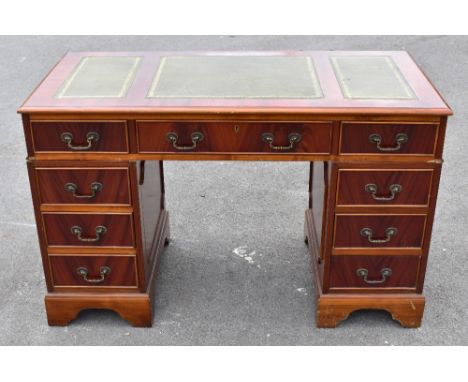 A reproduction mahogany pedestal desk, with an arrangement of nine drawers, on bracket feet, height 76cm, width 122cm, depth 