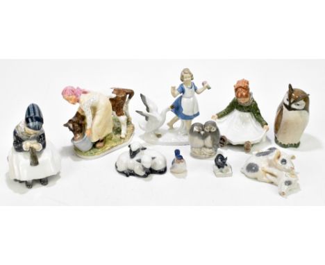 ROYAL COPENHAGEN; a collection of nine ceramic figures including a farmhand holding a milk pail and feeding a calf, height 16