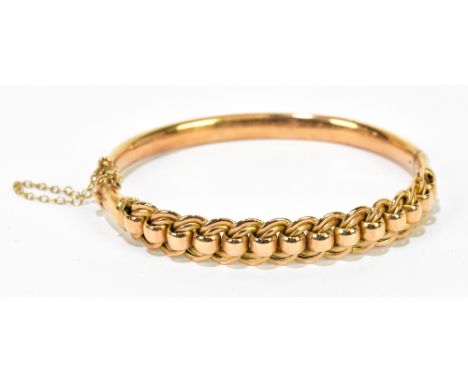 A 15ct gold hinged snap bangle with pierced loop upper section, interior width 58mm, approx 17g.