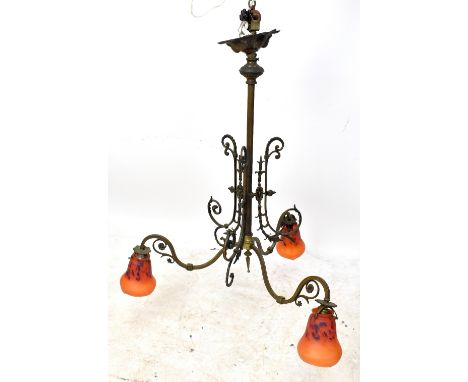 An Arts &amp; Crafts style iron framed chandelier with scrolling mounts and four Schneider glass shades with mottled decorati