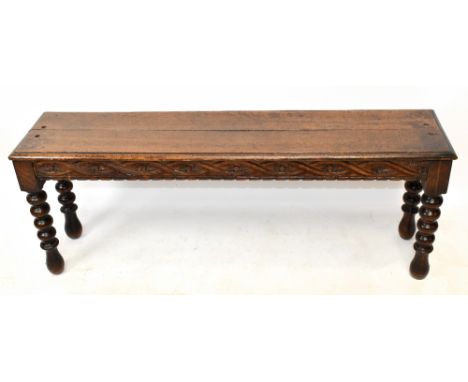 A late Victorian oak plank top window seat with carved frieze and bobbin turned legs, length 119cm.